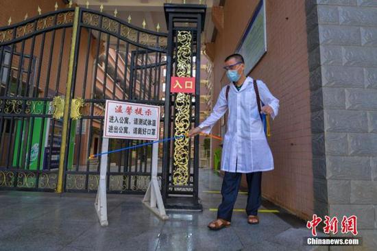 資料圖：?？诮?jīng)濟學院的工作人員在學生宿舍樓入口消毒。 中新社記者 駱云飛 攝