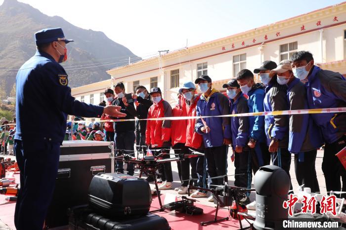 圖為消防指戰(zhàn)員為學(xué)生講解、演示先進救援裝備。　趙琳 攝