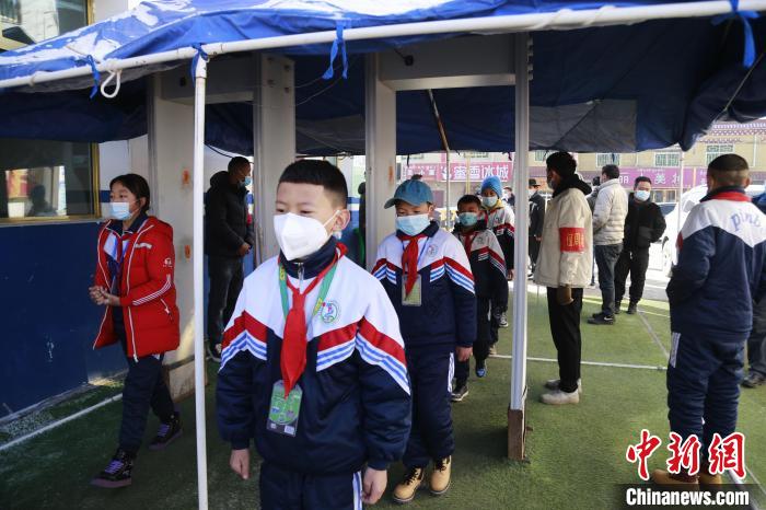 圖為學(xué)生測量體溫后進(jìn)入校園?！●R銘言 攝