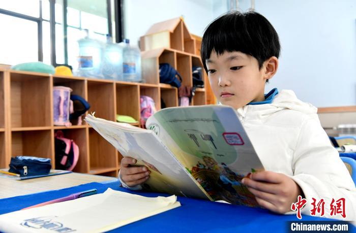 3月14日，西藏拉薩市第一小學(xué)一年級(jí)六班學(xué)生丁增樂(lè)吉在閱讀藏語(yǔ)課本?！±盍?攝