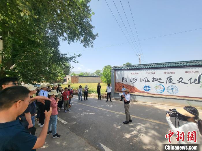 圖為中國地質(zhì)大學(xué)(北京)教授張緒教介紹村落情況?！『衍?攝