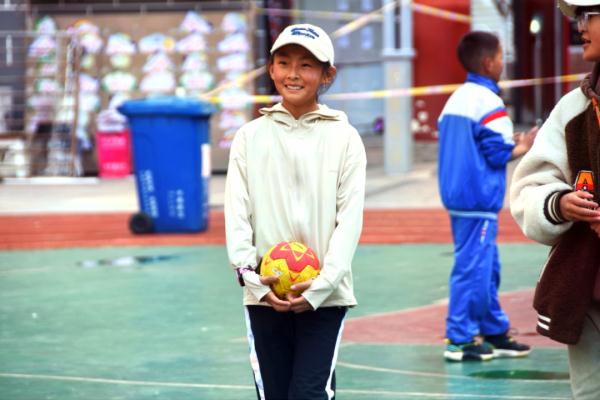 在高原上教孩子們打手球，“慢慢兒來(lái)，甭著急！”