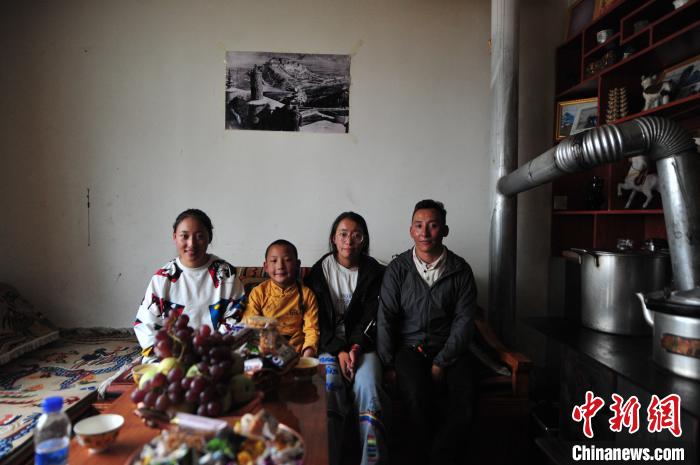 圖為8月12日，2018年7月從距那曲市色尼區(qū)城區(qū)那曲鎮(zhèn)90千米外的古露鎮(zhèn)當桑村搬遷至城區(qū)的旦增(右一)與家人在80多平方米的新家合影(資料圖)?！垈?攝