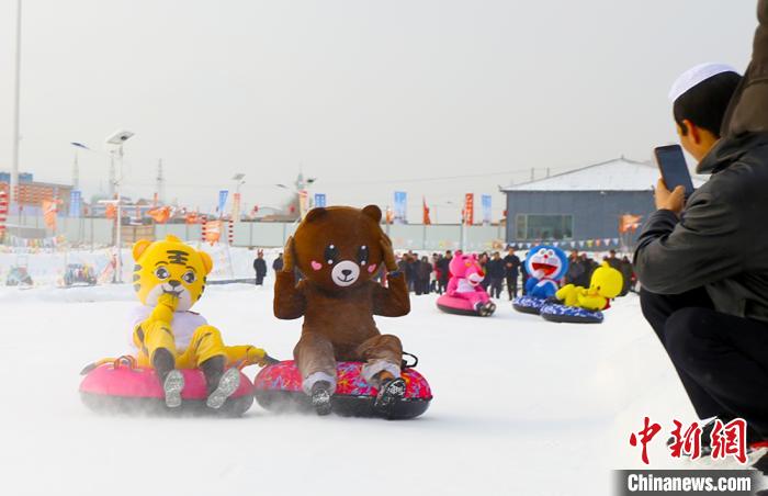 圖為臨夏市南龍鎮(zhèn)馬家莊村舉辦的鄉(xiāng)村文化旅游節(jié)上，游客穿著卡通服裝在體驗雪上飛碟項目。近年來，臨夏州形成了“春賞花、夏避暑、秋摘果、冬玩雪”的全季節(jié)旅游產(chǎn)品體系。(資料圖) 高展 攝