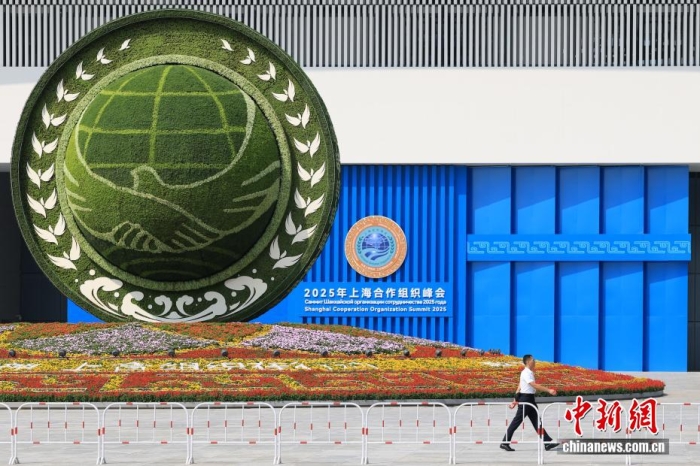 8月31日，天津，一名工作人員從2025年上海合作組織峰會(huì)主會(huì)場(chǎng)外的景觀花壇旁經(jīng)過(guò)。當(dāng)日，2025年上海合作組織峰會(huì)在天津舉行。<a target='_blank' href='/'><p  align=