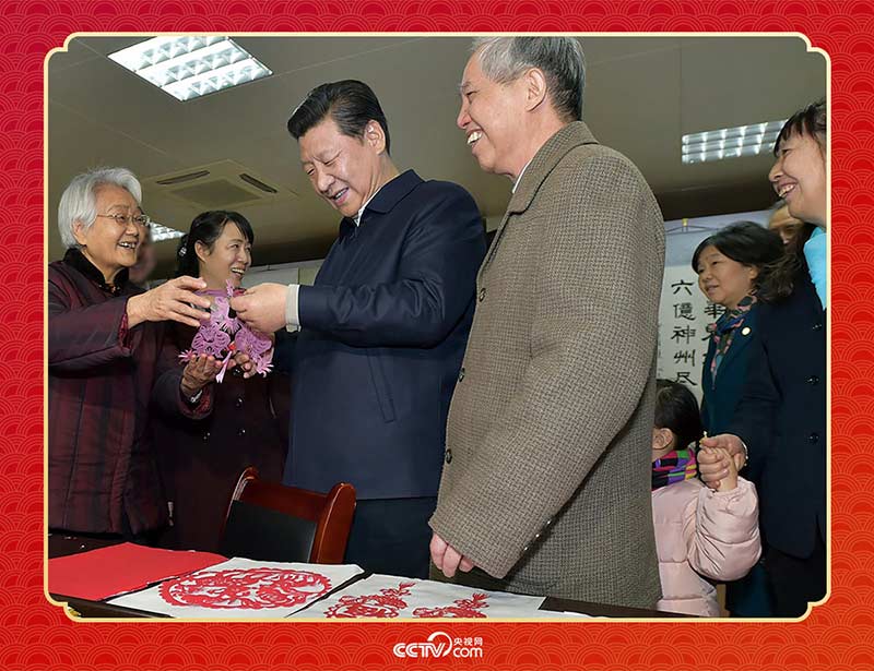 2015年2月15日，習(xí)近平在西安市雁塔區(qū)電子城街道二〇五所社區(qū)服務(wù)中心欣賞社區(qū)居民的剪紙作品。