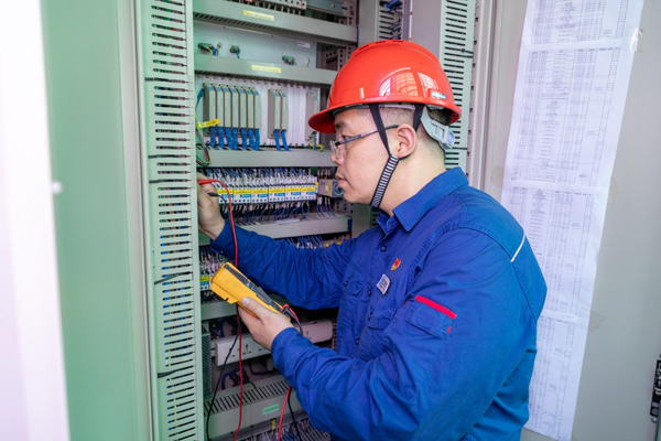 呂曉勇在保護盤柜前檢查二次回路接線情況。受訪者供圖