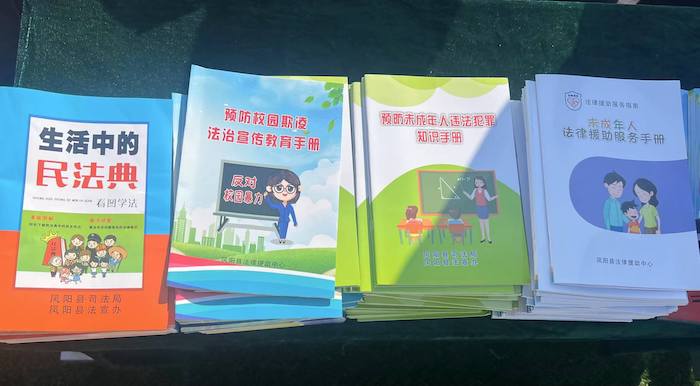 有關部門分發(fā)的普法宣傳冊。人民網 高清揚攝