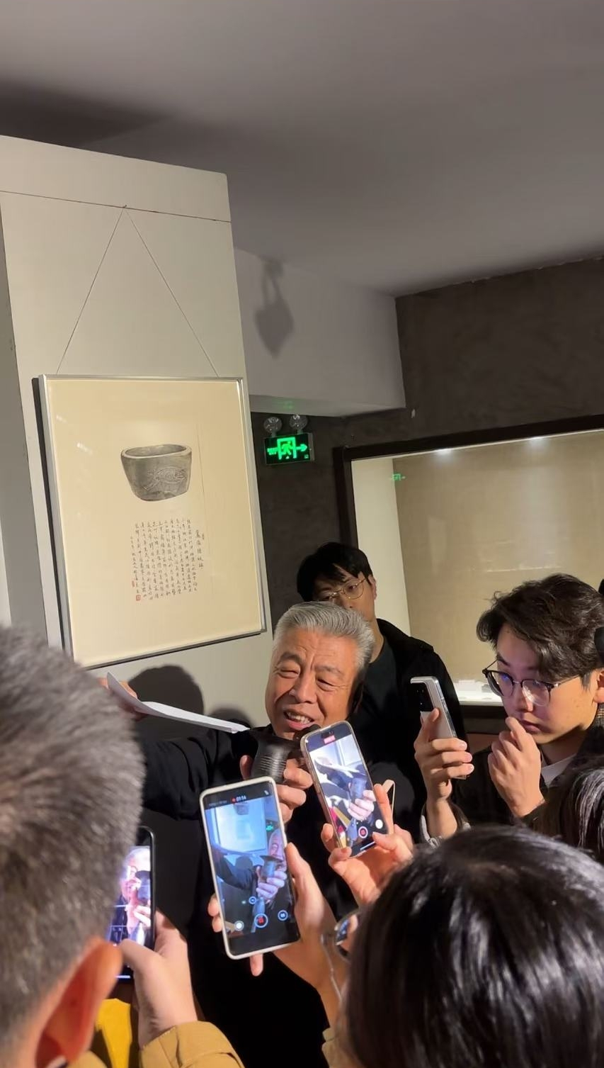 黑陶邢文化博物館館長邢葆東展示兩張相疊的A4紙，向記者解釋此為杯口的厚度。