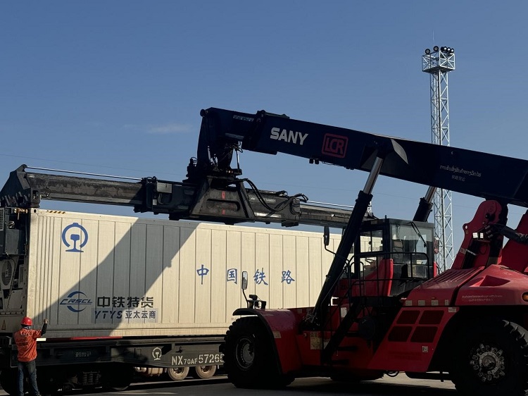 春節(jié)期間，起重機吊裝即將發(fā)運的冷鏈集裝箱。李加勇攝