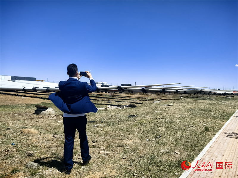 外媒記者拍攝廠房外的風(fēng)力渦輪發(fā)電機(jī)的巨型漿葉。人民網(wǎng) 楊春燕攝