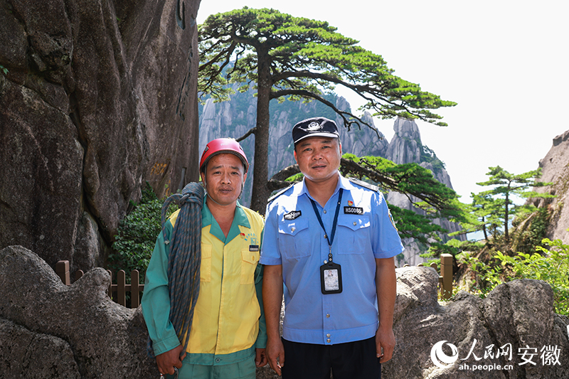 全國道德模范李培生（左）和胡曉春在迎客松前合影。人民網(wǎng)記者 張俊攝