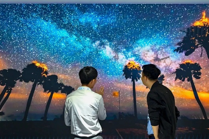 長(zhǎng)春光博會(huì)希達(dá)電子展區(qū)，一位工作人員正在給一位觀眾講解。（長(zhǎng)春新區(qū)供圖）