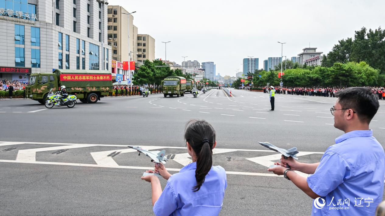 航空工業(yè)沈飛的青年技術(shù)人員拿著受閱戰(zhàn)機(jī)的模型迎接烈士遺骸。航空工業(yè)沈飛供圖