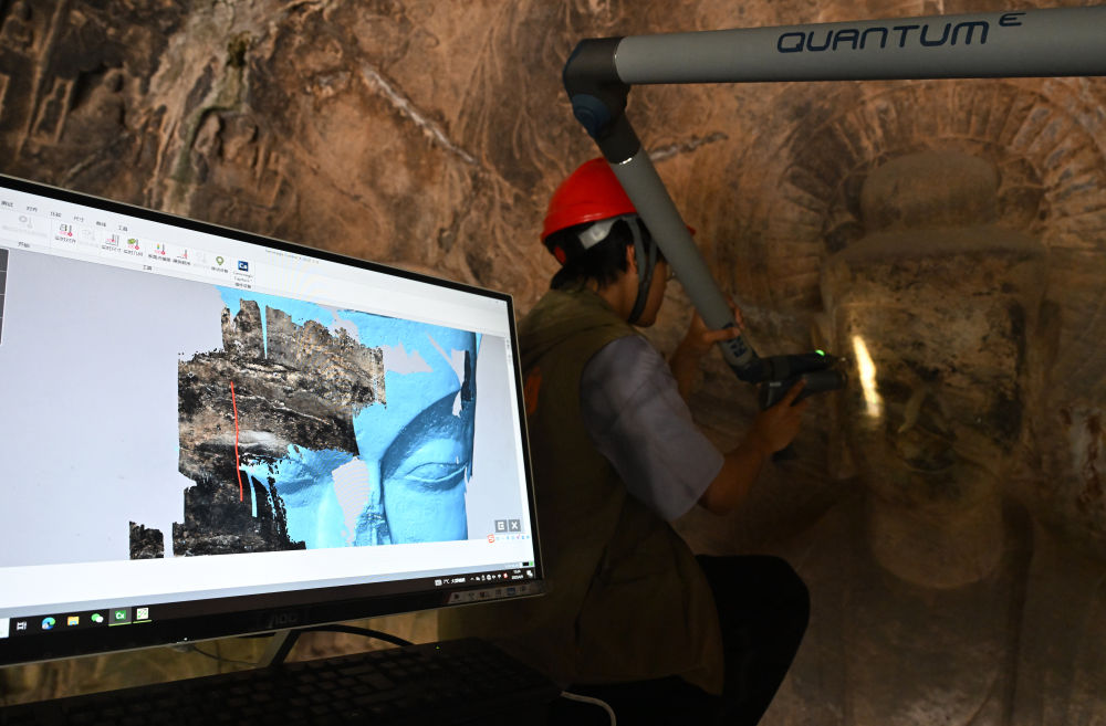 2025年4月9日，武漢大學(xué)文化遺產(chǎn)智能計(jì)算實(shí)驗(yàn)室團(tuán)隊(duì)成員在魏字洞使用關(guān)節(jié)臂掃描儀對佛像進(jìn)行數(shù)字化掃描。圖片來源新華社