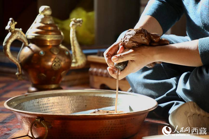 牛角鉆孔，將木泥擠出。人民網記者 次仁羅布攝