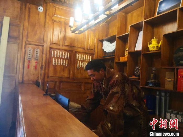 圖為桑杰才讓用電腦處理財務(wù)?！∈缝o靜 攝