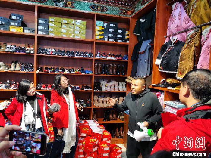 圖為中外媒體在玉樹州玉樹市甘達(dá)村采訪?！?zhí)砀?攝