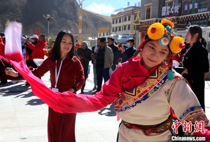 圖為中外記者向當(dāng)?shù)孛癖妼W(xué)習(xí)民族歌舞文化。　張?zhí)砀?攝