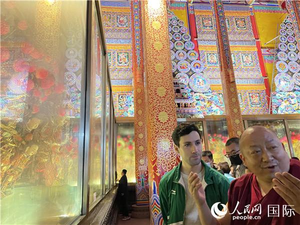 7月25日，省級非物質(zhì)文化遺產(chǎn)項目塔爾寺酥油花的代表性傳承人朋措堅參（右）在塔爾寺酥油花館講解酥油花的制作過程。人民網(wǎng) 謝瑩攝