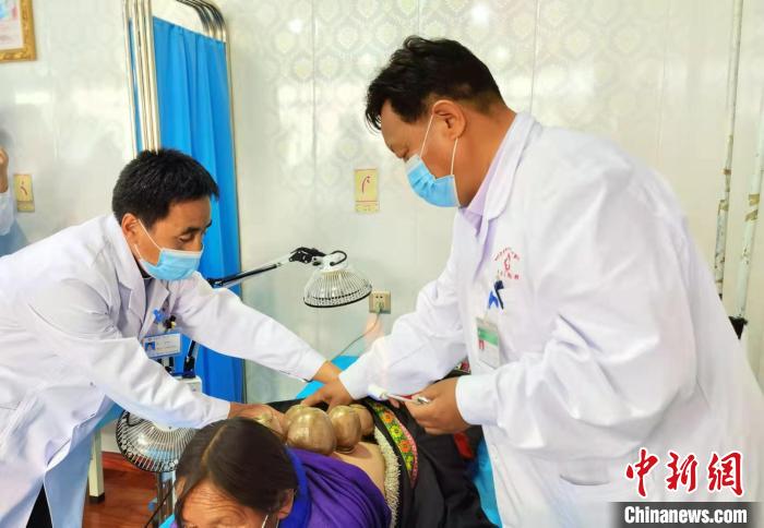 圖為看照加手把手帶徒弟加老(左一)進(jìn)行拔罐療法?！堟?攝