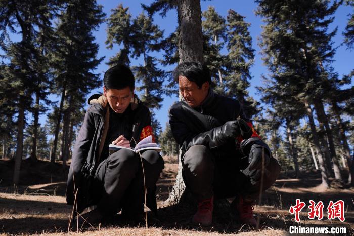 圖為桑杰加(左)和同事記錄巡查結(jié)果。　馬銘言 攝