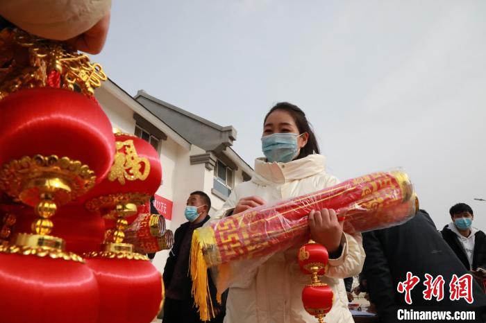 27日，蘭州新區(qū)為舟曲避險搬遷移民送“春節(jié)包”，楊周馬草前往領(lǐng)取，紅色寓意來年的日子紅紅火火。　魏建軍 攝