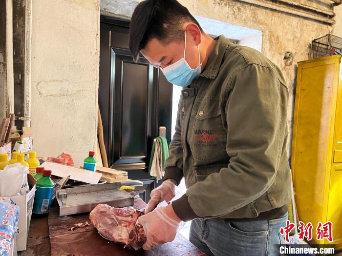 圖為雪豹“奶爸”史壽軍正在準(zhǔn)備投喂雪豹的食材?！●R銘言 攝