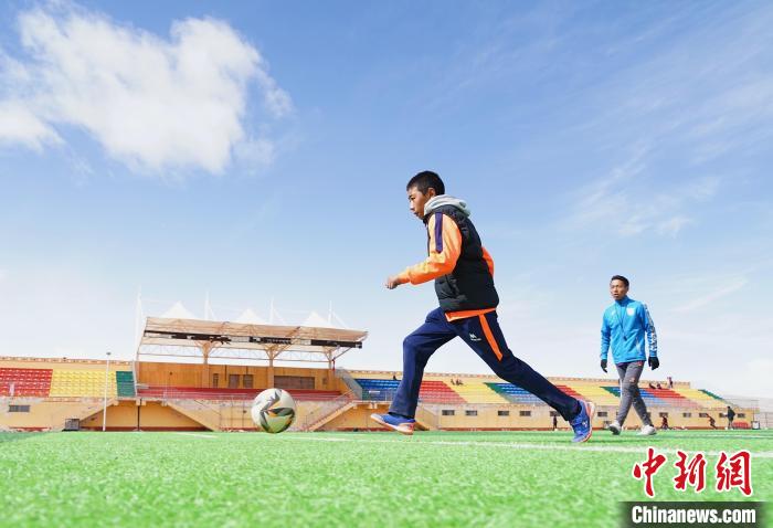 圖為一名男孩運(yùn)球射門。　馬銘言 攝