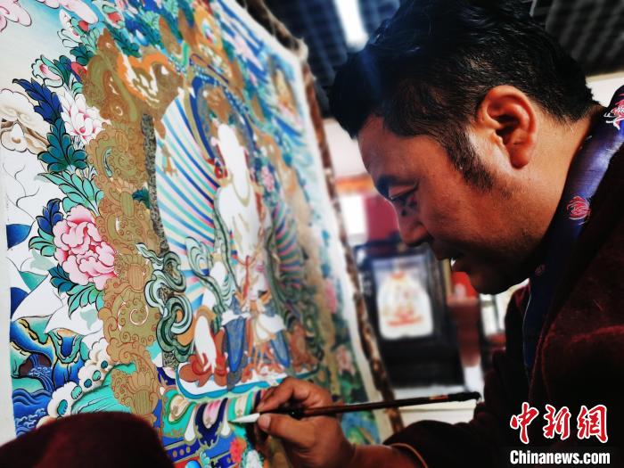 圖為久美尖措創(chuàng)作唐卡?！?zhí)砀?攝