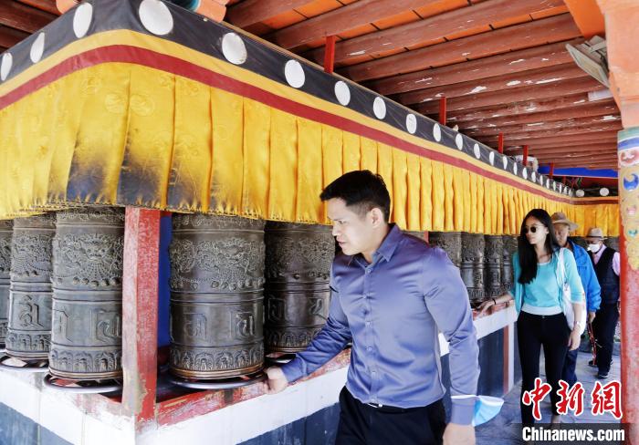 圖為外籍嘉賓體驗藏族傳統(tǒng)轉經筒。　馬銘言 攝