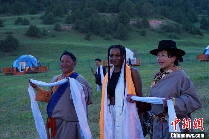 圖為當?shù)孛癖娕c外籍留學生合影留念。　馬銘言 攝