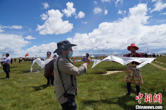 圖為一名外籍攝影師記錄當地藏族歡迎儀式。　馬銘言 攝