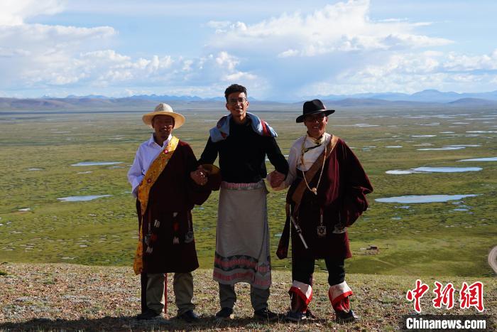 圖為一名留學生身穿自己國家的服飾和藏族民眾合影留念?！●R銘言 攝