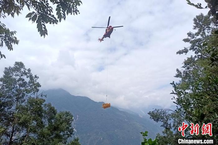 直升機(jī)起飛將搶修塔材運(yùn)往海拔1950米的110千伏唐下線29號(hào)塔位。　徐慶明 攝