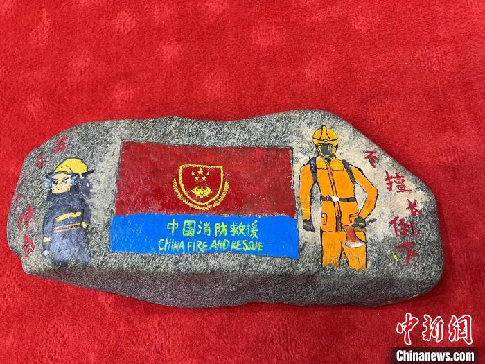 圖為玉樹消防指戰(zhàn)員創(chuàng)作的石頭畫作品《我有一個(gè)特點(diǎn)“不擅長倒下”》?！O瑞祥 攝