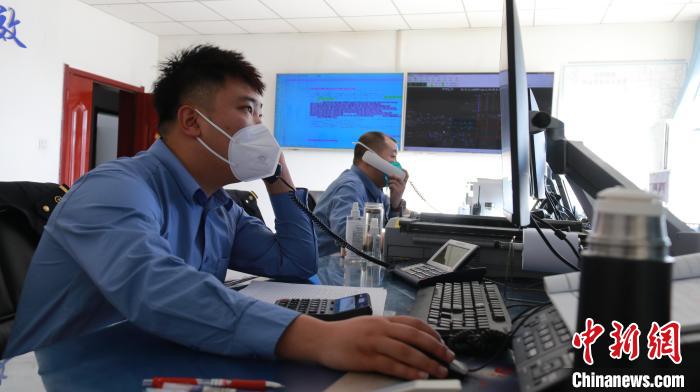 圖為貨運調度人員與外勤工作人員聯(lián)系掌握車輛裝載情況?！±钌?攝