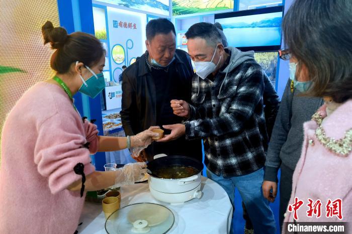 圖為杭州市民品嘗茶卡羊肉。　李雋 攝