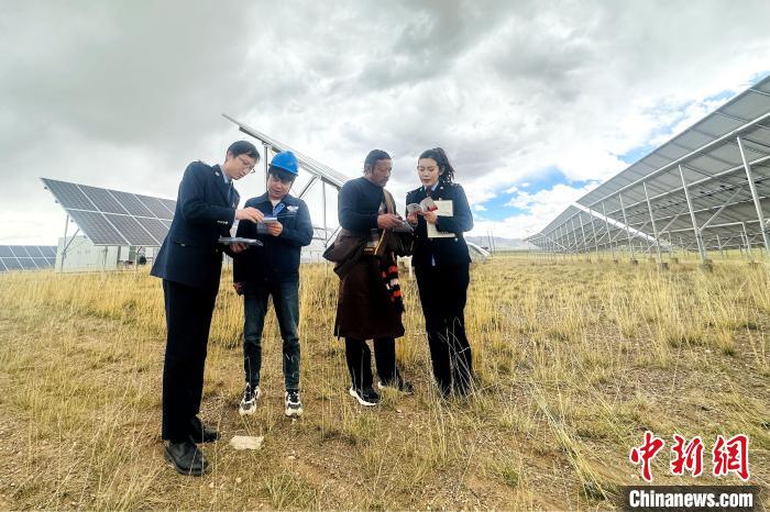 圖為稅務(wù)干部上門開展稅費輔導(dǎo)?！》劫F龍 攝