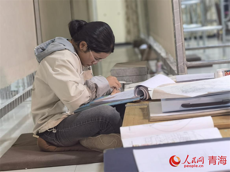 正在學(xué)習(xí)畫底稿的尕讓旺姆。人民網(wǎng) 陳明菊攝
