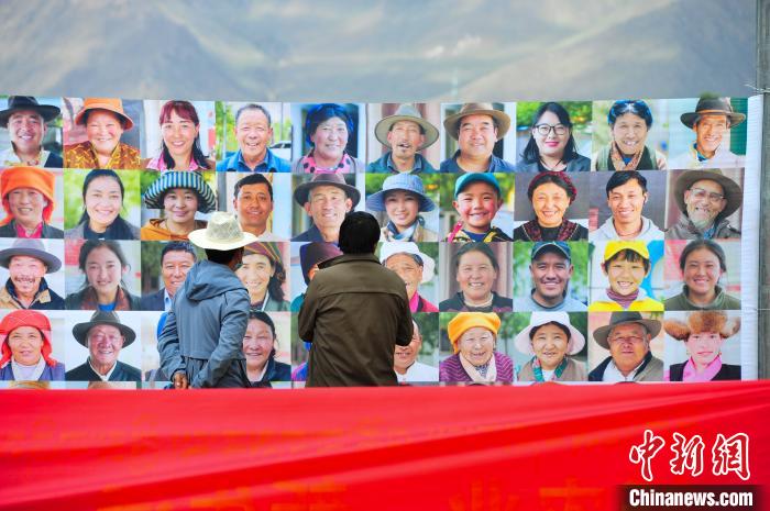 圖為當(dāng)?shù)孛癖娫谟^看展板上的笑臉。　張偉 攝