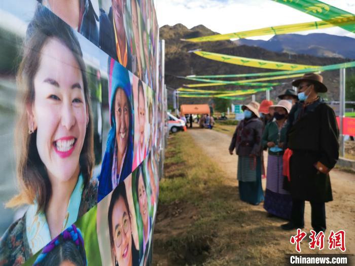 圖為當(dāng)?shù)孛癖娫谟^看展板上的笑臉?！垈?攝