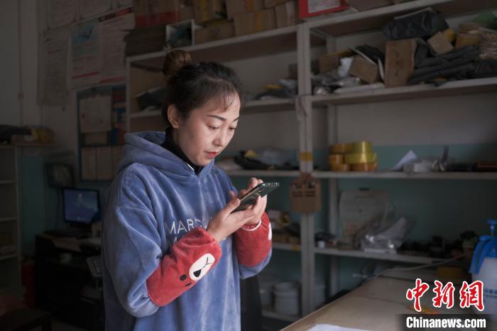 正在快遞站點(diǎn)內(nèi)忙碌的楊莉春。　何蓬磊 攝