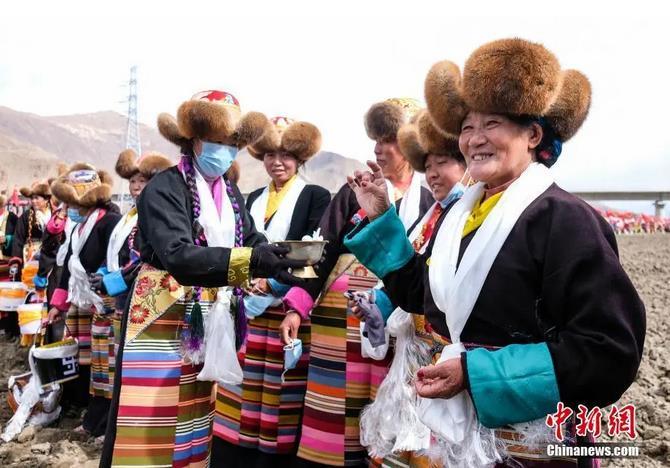 資料圖：西藏自治區(qū)拉薩市曲水縣才納鄉(xiāng)協(xié)榮村參加春耕儀式的村民互敬青稞酒。按照傳統(tǒng)，當(dāng)?shù)卮迕裆碇?jié)日盛裝，舉行隆重的儀式，祈福一年的豐收。<a target='_blank' ><p  align=