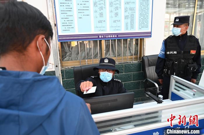 圖為移民管理警察登記完身份信息后將證件歸還給行人。　趙朗 攝