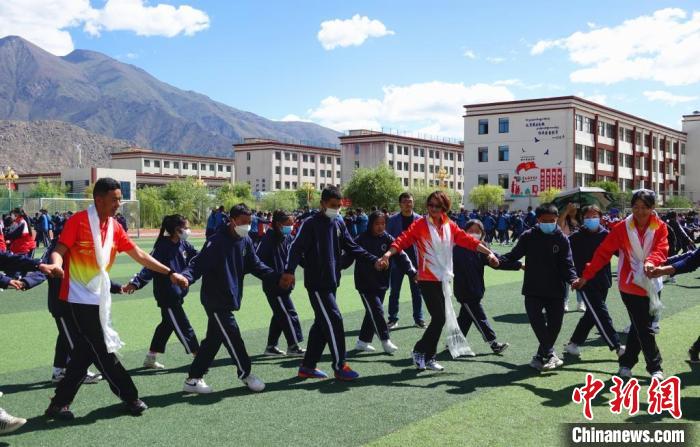 圖為世界冠軍與拉薩阿里地區(qū)高級(jí)中學(xué)學(xué)生一起跳鍋莊?！∪轿木?攝