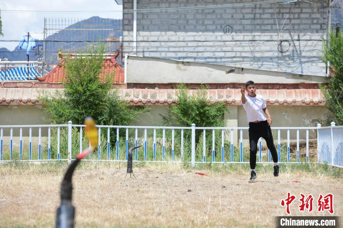 圖為西藏自治區(qū)拉薩市賽馬場(chǎng)內(nèi)市民在體驗(yàn)“打牛角”項(xiàng)目?！∝暩聛?lái)松 攝