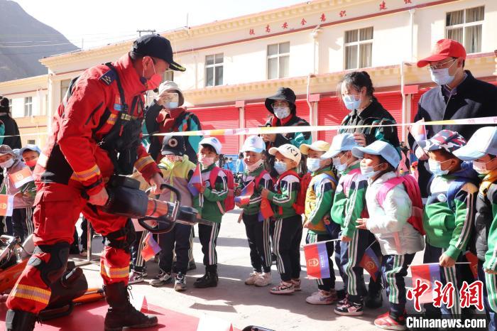 圖為消防指戰(zhàn)員為學(xué)生講解、演示先進(jìn)救援裝備?！≮w琳 攝