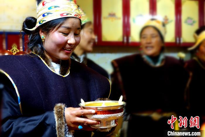 圖為藏族姑娘向客人敬酒?！∪轿木?攝