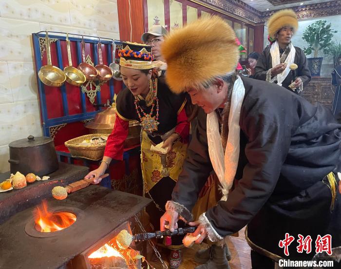 圖為人們?cè)诨鹕峡竟?jié)日美食“結(jié)達(dá)”?！∪轿木?攝